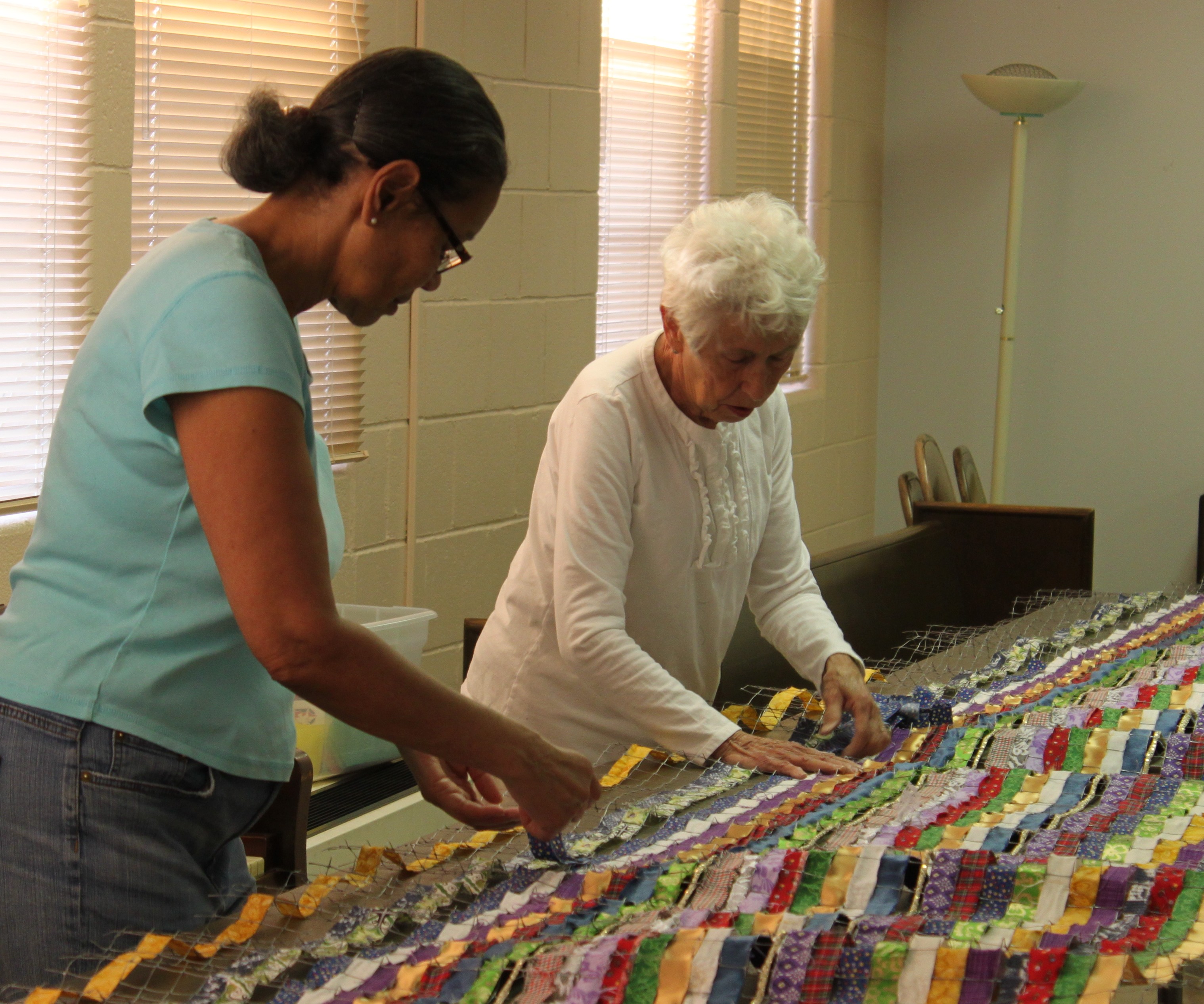 Two women weaving Bound Together. Photo by Linda Henke.